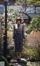 A woman standing on a rock in a garden.