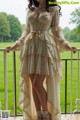 A woman in a white dress standing on a balcony.