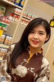 A woman standing in front of a shelf in a store.