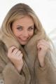 A woman in a fur coat posing for a picture.