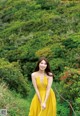 A woman in a yellow dress posing for a picture.