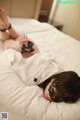 A woman laying on a bed wearing a black mask.