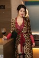 A woman in a leopard print robe holding a glass of wine.