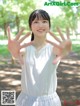 A young woman in a white shirt and skirt posing for a picture.