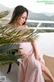 A woman in a pink dress sitting on a balcony.