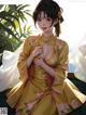 A woman in a yellow kimono sitting on a bed.